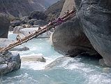 202 Log Across Miristi Khola A few minutes later we were all assembled on the banks of the Miristi Khola, a turbulent river that drains all the waters from the upper basins of Annapurna, the Great Barrier and the Nilgiris. From now on the route lay along the opposite bank, so we had to cross over (Maurice Herzog, Annapurna). The boys found an old log with some two or three inch stumps sticking out put laid it cross the river. It tilted downward at an angle of about 20 degrees, about 10 feet above the river.